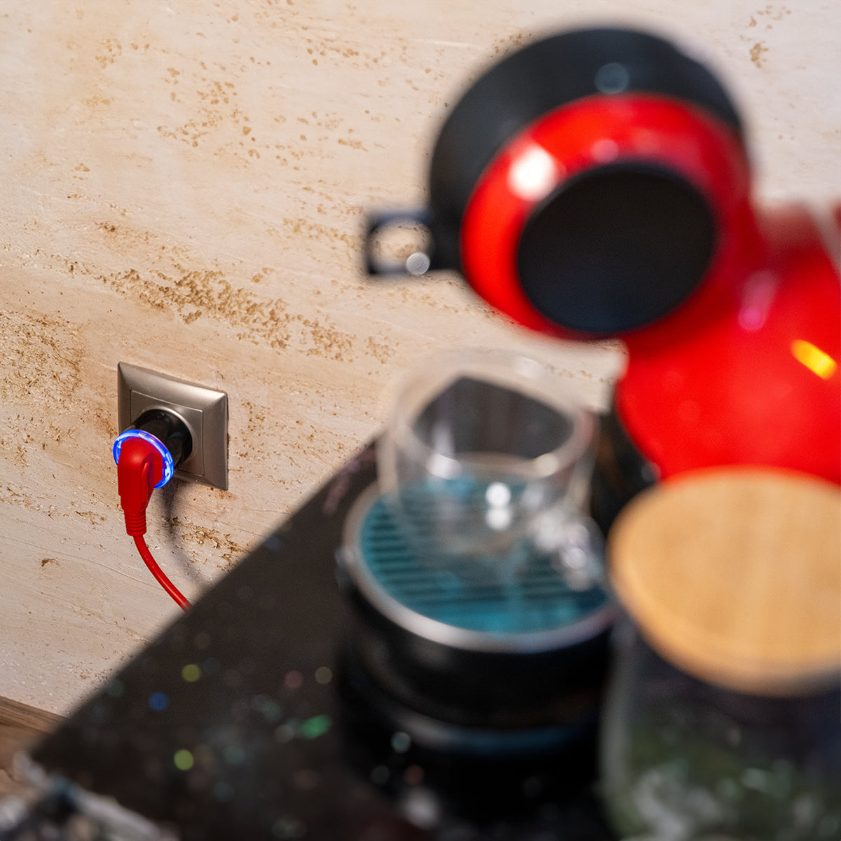Smarte Shelly-Steckdose zwischen Wandsteckdose und roter Kaffeemaschine